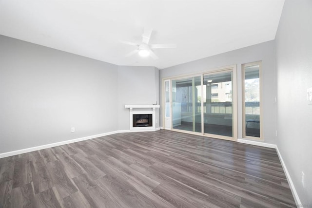 unfurnished living room with dark wood-type flooring and ceiling fan