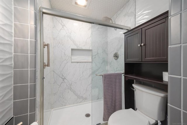 bathroom with an enclosed shower and toilet