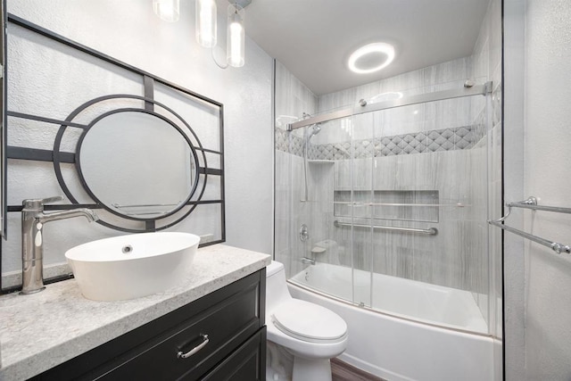 full bathroom featuring toilet, enclosed tub / shower combo, and vanity