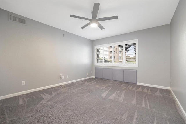 carpeted spare room featuring ceiling fan