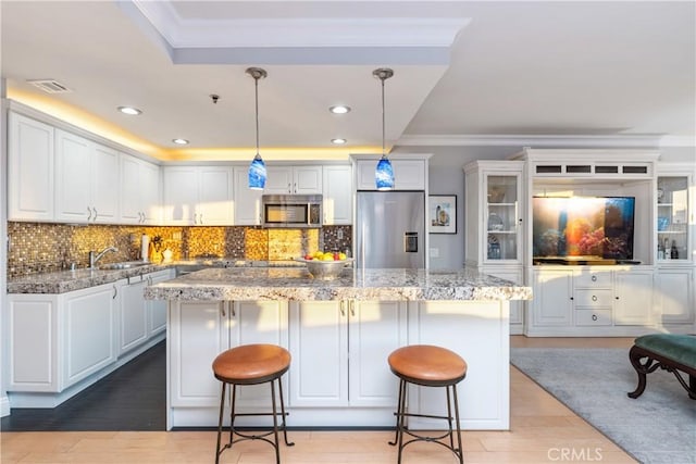 kitchen featuring a center island, a breakfast bar, pendant lighting, and appliances with stainless steel finishes