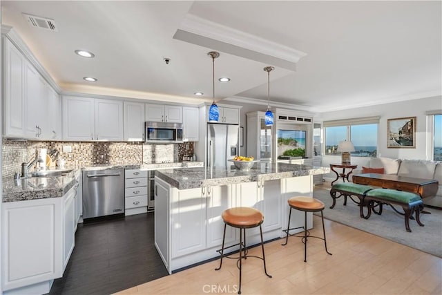 kitchen featuring white cabinets, stainless steel appliances, and a kitchen island