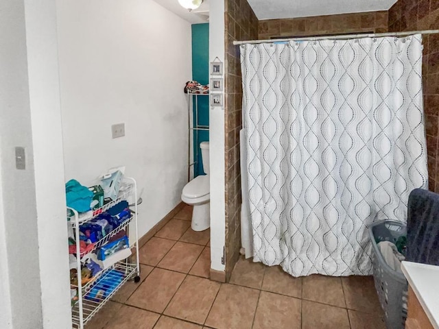 bathroom with tile patterned floors, toilet, and curtained shower