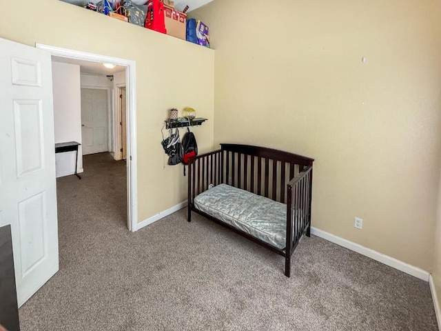 bedroom featuring a nursery area and carpet floors