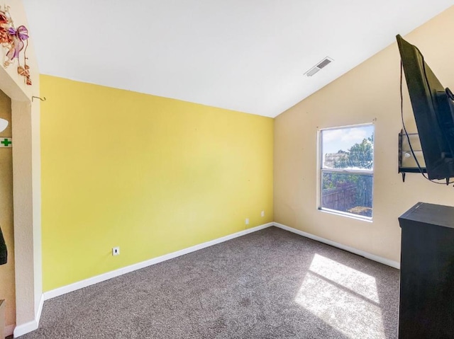 carpeted empty room featuring vaulted ceiling