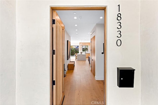 hallway with light hardwood / wood-style floors