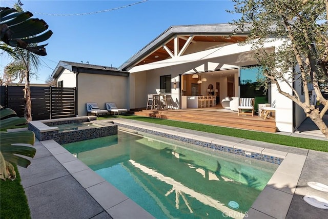 rear view of house featuring a swimming pool with hot tub and an outdoor bar