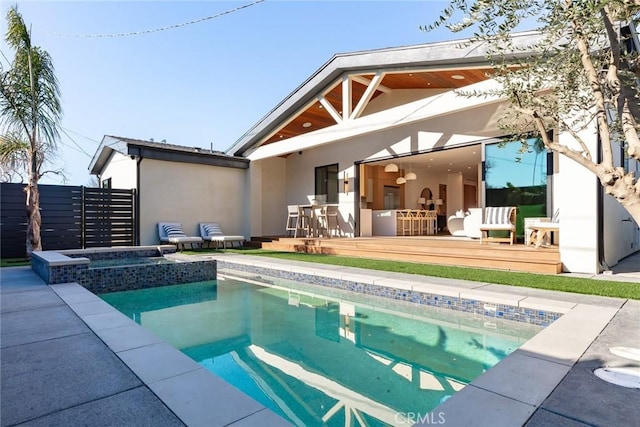 rear view of property with a pool with hot tub