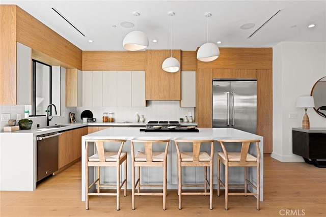 kitchen with stainless steel appliances, white cabinets, hanging light fixtures, and a center island