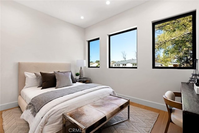 bedroom with wood-type flooring and multiple windows