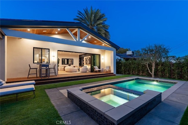 exterior space featuring a deck and an in ground hot tub