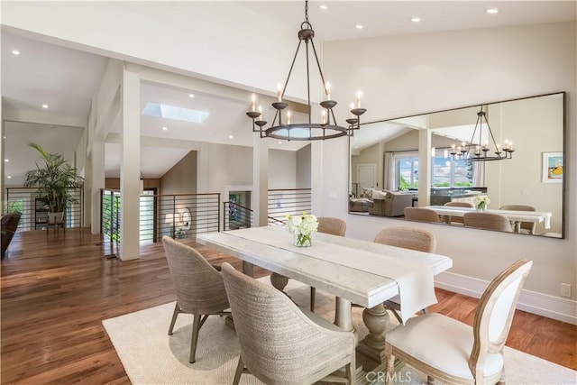 dining room featuring a skylight, hardwood / wood-style flooring, and high vaulted ceiling