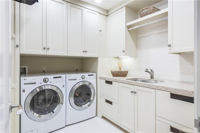 washroom with washer and clothes dryer, sink, and cabinets