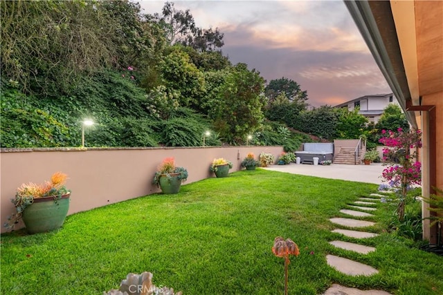 yard at dusk featuring a patio