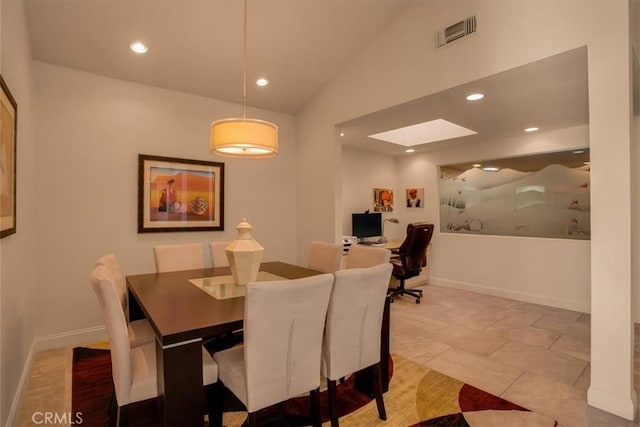 dining space with vaulted ceiling and light tile patterned flooring