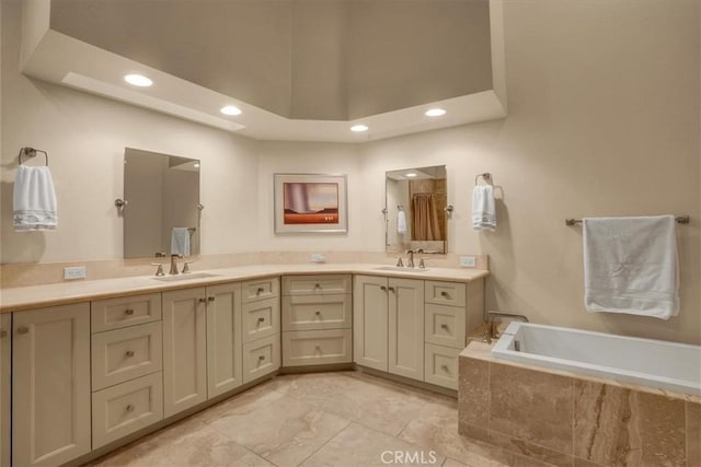 bathroom featuring vanity, a towering ceiling, and a relaxing tiled tub