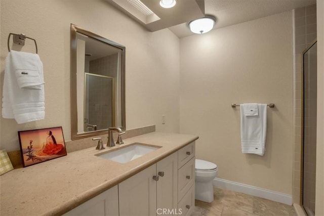 bathroom featuring vanity, a shower with shower door, and toilet