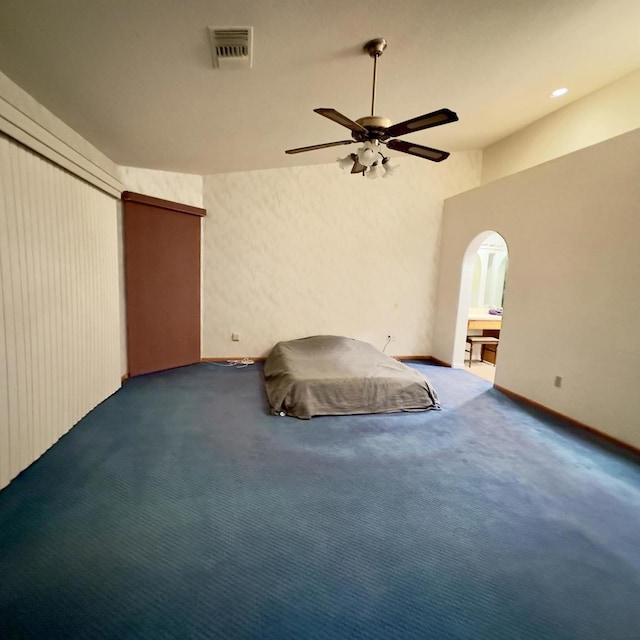 unfurnished bedroom featuring ceiling fan, vaulted ceiling, ensuite bathroom, and carpet flooring