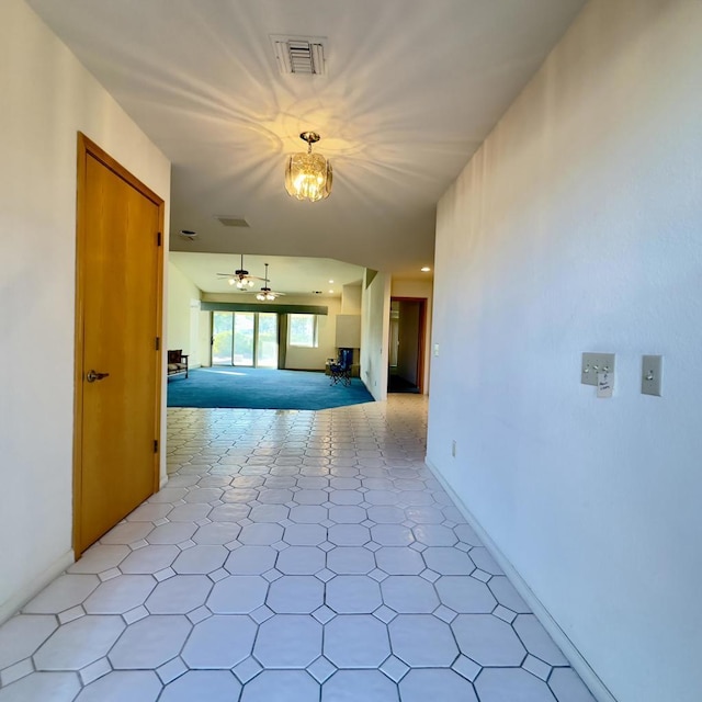 hallway with an inviting chandelier