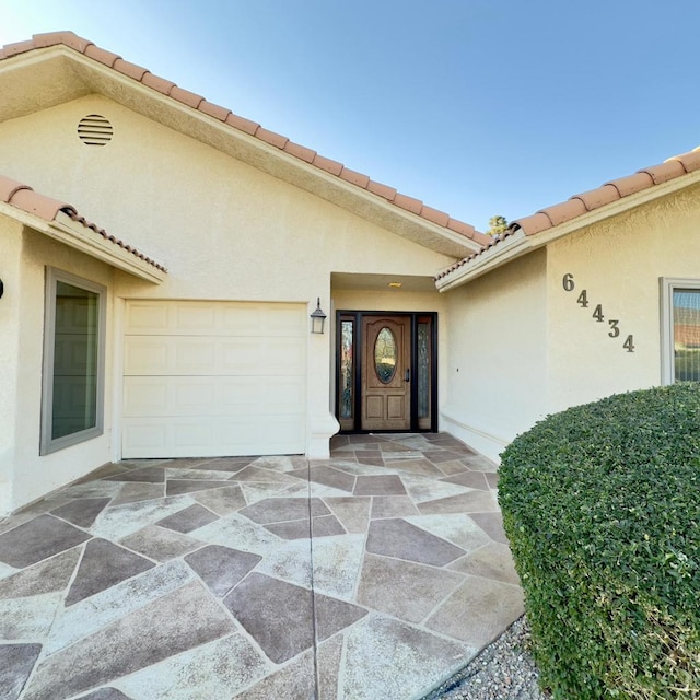 doorway to property with a garage