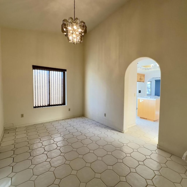 unfurnished room with plenty of natural light and a chandelier