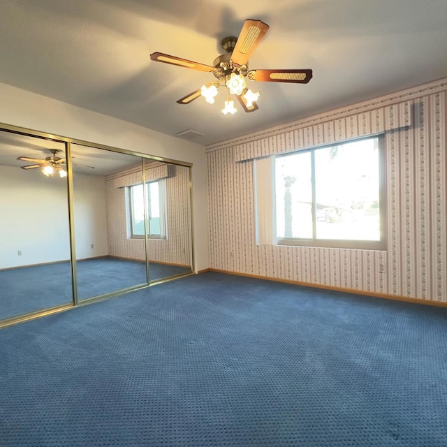 unfurnished bedroom featuring ceiling fan, a closet, and carpet flooring