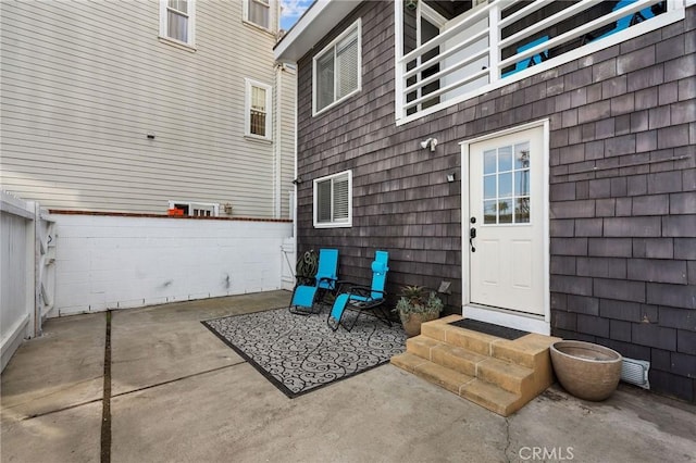 property entrance with a patio and fence