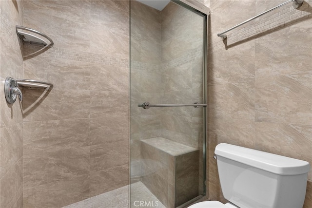 bathroom featuring toilet and a tile shower