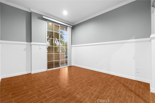 spare room featuring wood-type flooring and crown molding