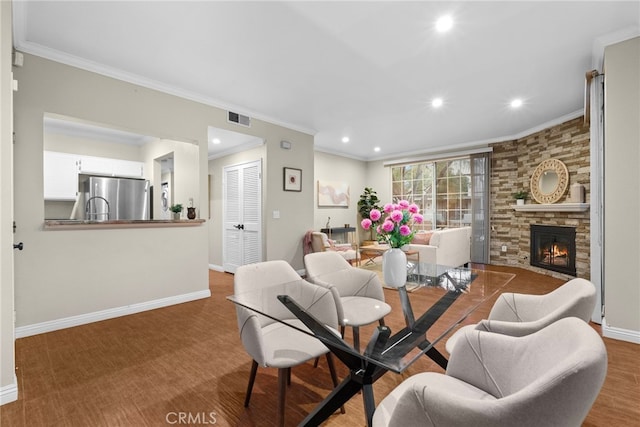 dining space featuring crown molding and a stone fireplace