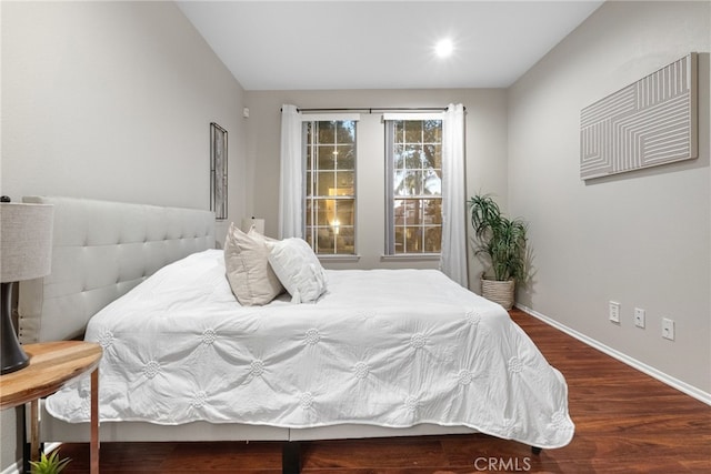 bedroom with dark hardwood / wood-style flooring