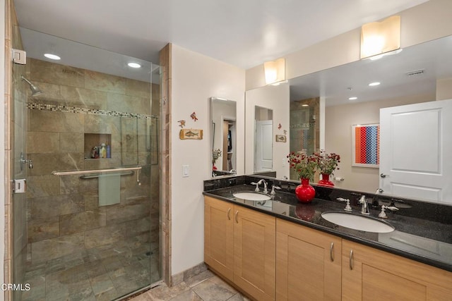 bathroom with a shower with door and vanity