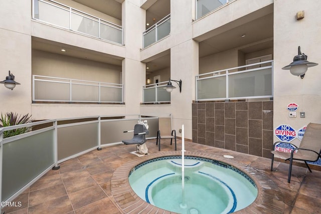 view of pool with a hot tub