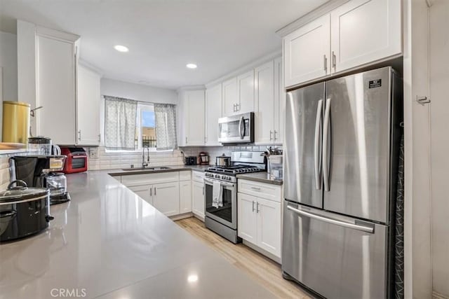 kitchen featuring decorative backsplash, sink, white cabinets, and stainless steel appliances