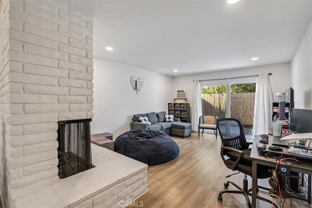 home office featuring light hardwood / wood-style floors and a fireplace