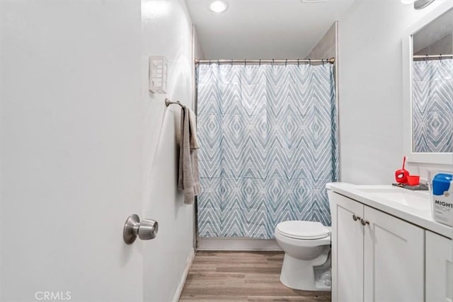 bathroom featuring wood-type flooring, toilet, vanity, and a shower with shower curtain