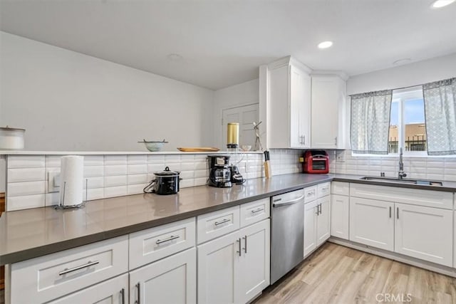 kitchen featuring dishwasher, sink, white cabinetry, and light hardwood / wood-style floors