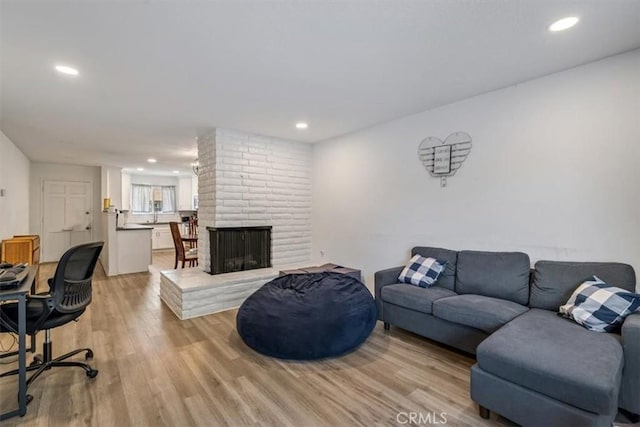 living room with light hardwood / wood-style floors and a fireplace