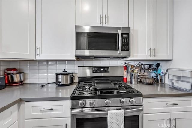 kitchen with stainless steel appliances, decorative backsplash, and white cabinets