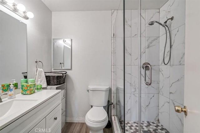 bathroom with a shower with shower door, hardwood / wood-style flooring, toilet, and vanity