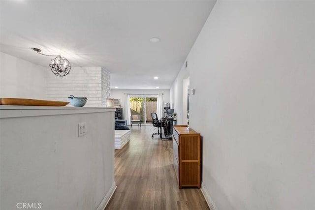 corridor with light hardwood / wood-style floors and a chandelier