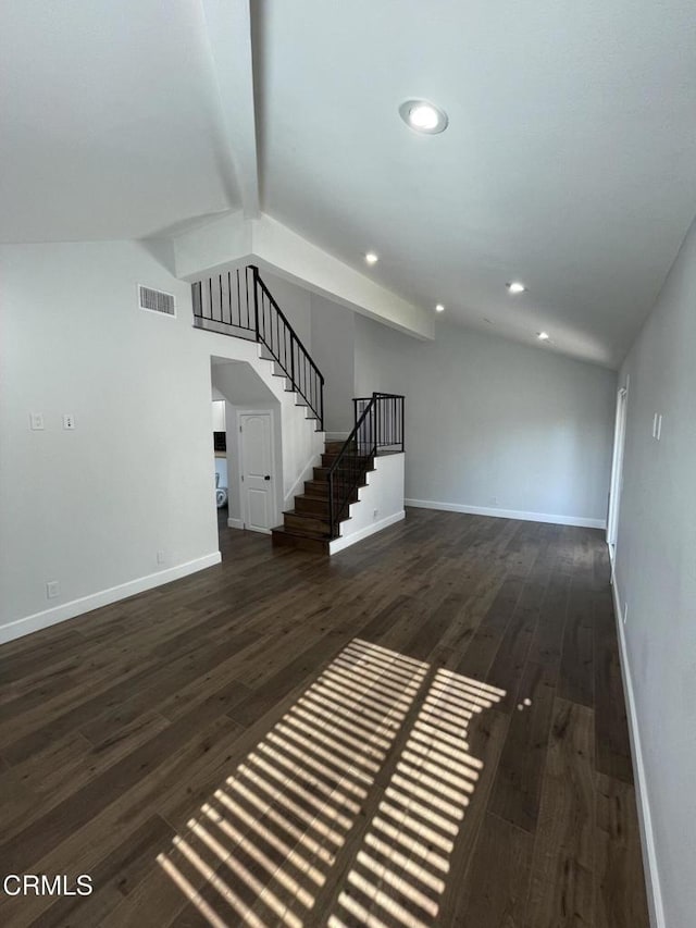 unfurnished living room featuring dark hardwood / wood-style flooring and vaulted ceiling with beams