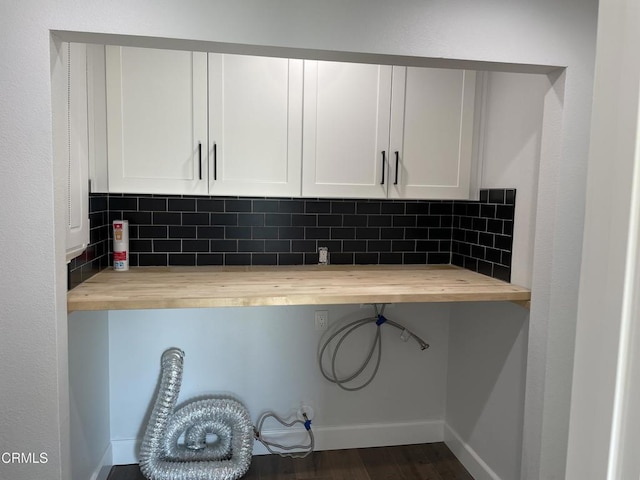 kitchen featuring white cabinetry, backsplash, and butcher block countertops