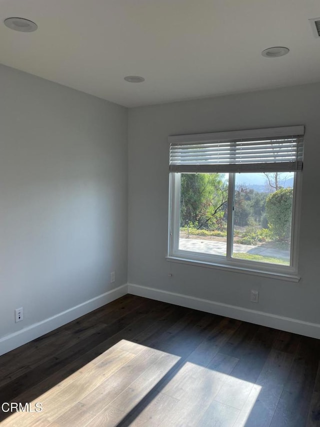 empty room with dark hardwood / wood-style flooring