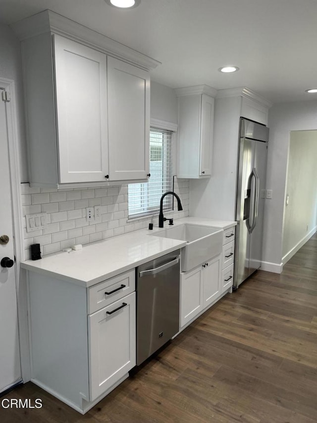 kitchen with tasteful backsplash, white cabinets, sink, and stainless steel appliances