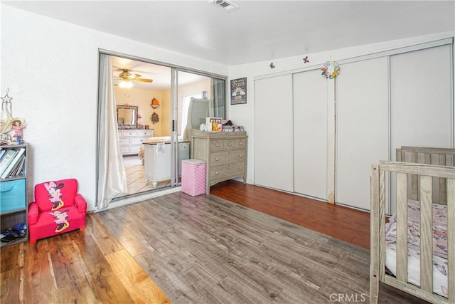 bedroom featuring hardwood / wood-style floors and a nursery area