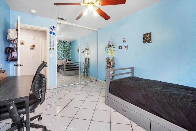 tiled bedroom featuring ceiling fan and a closet