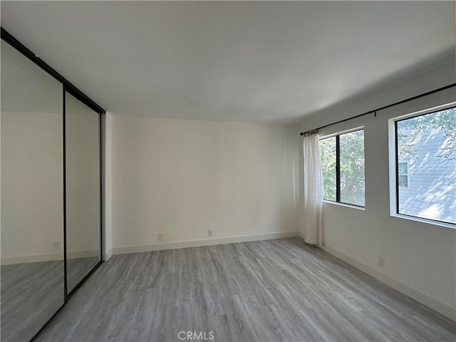 unfurnished bedroom featuring light wood-type flooring and a closet