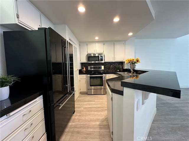 kitchen featuring sink, white cabinetry, stainless steel appliances, and light wood-type flooring