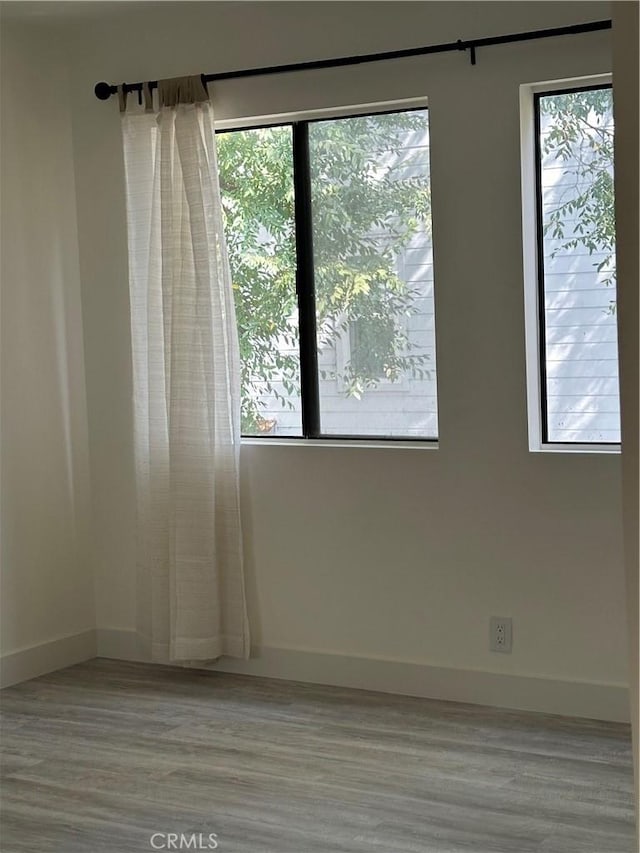 empty room with light wood-type flooring and plenty of natural light